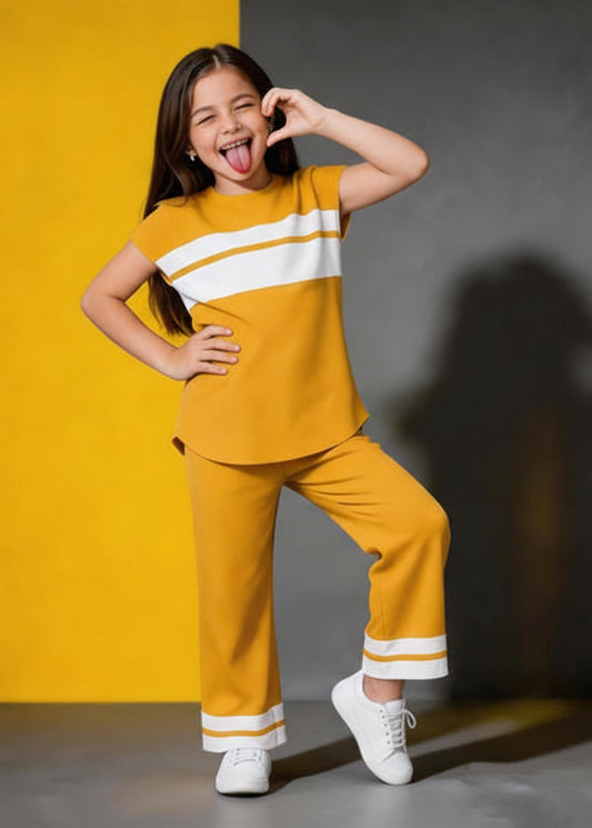 Child in a yellow outfit with white stripes posing against a yellow and gray background